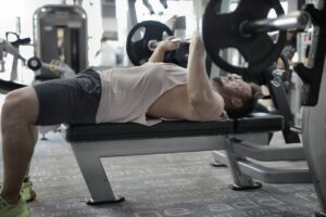 Man lifting weight bench press in gym freeweights