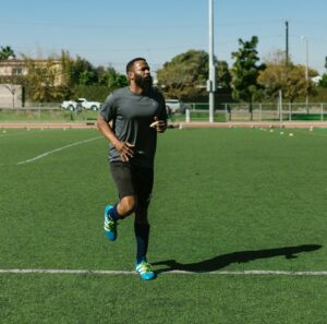 Man running on grass wearing football clothes