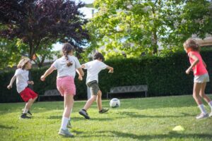 kids playing soccer football on green grass