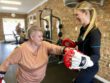 lady boxing with partner exercise physiologist in gym